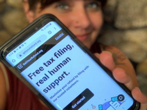 Image of taxpayer holding a smart phone with the Get Your Refund home page.